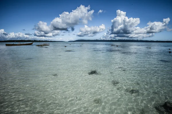 Transparentní mořské vody a modrou oblohu s mraky — Stock fotografie