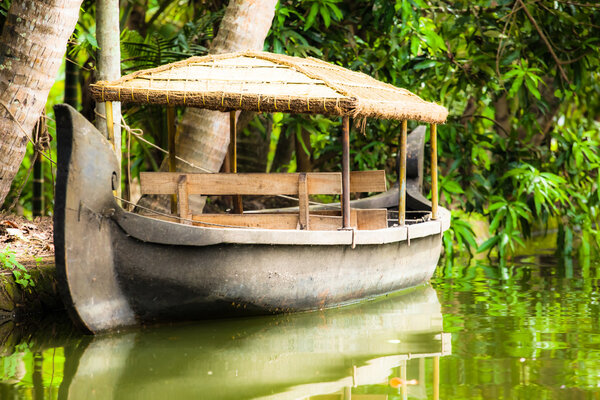 House boat in backwaters near palms in Alappuzha, Kerala, India