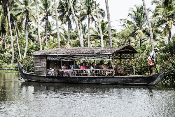 House boat in backwaters near palms in Alappuzha, Kerala, India