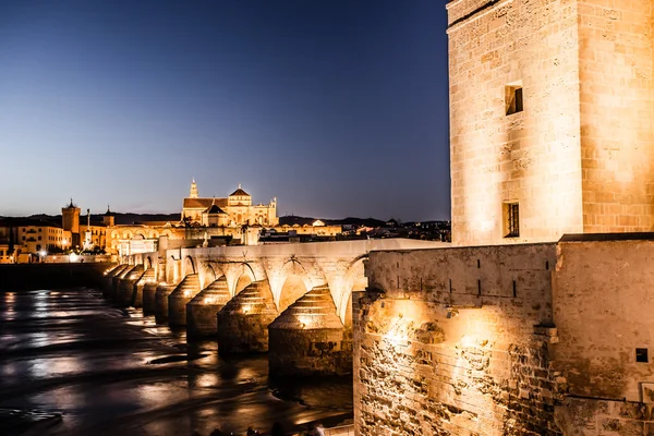 Римский мост на реке Гвадалкивир и Великая мечеть (собор Мезкиты) в сумерках в городе Кордова, Андалусия, Испания . — стоковое фото