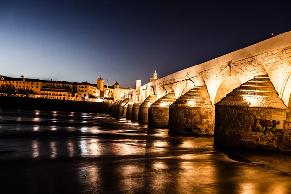 Římský most přes řeku guadalquivir a Velká mešita (katedrála mezquita) za soumraku v městě cordoba, Andalusie, Španělsko. — Stock fotografie