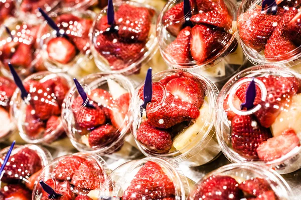 Fruit Salad arranged in plastic cups on a market stall focus on middle front cup. — Stock Photo, Image