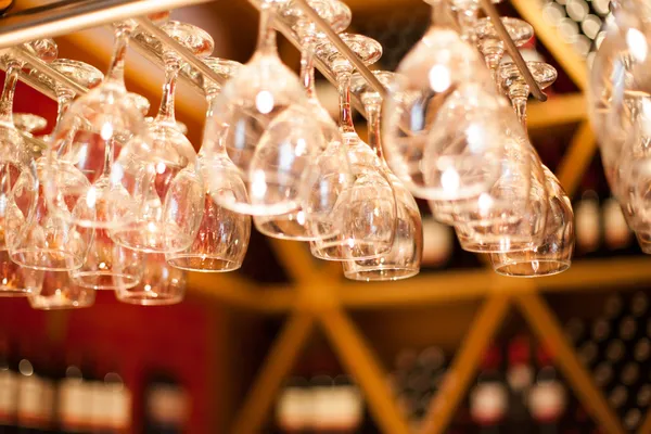 Empty glasses for wine above a bar rack — Stock Photo, Image