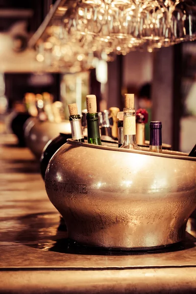 Served white wine with empty glasses on a sunny bar table — Stock Photo, Image