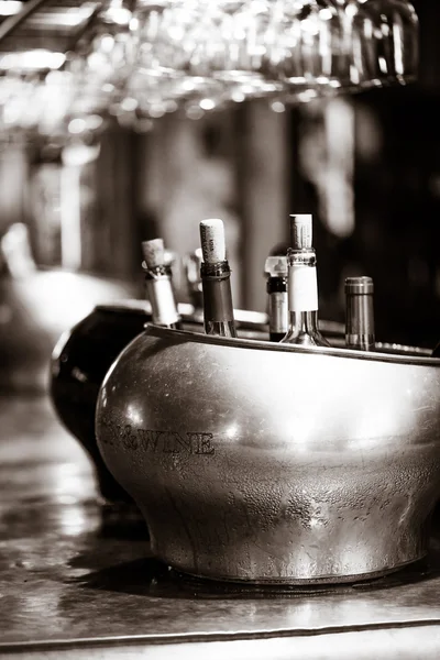 Sirve vino blanco con vasos vacíos en una mesa de bar soleada — Foto de Stock