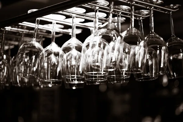 Empty glasses for wine above a bar rack — Stock Photo, Image