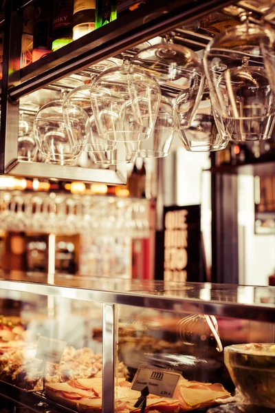 Empty glasses for wine above a bar rack — Stock Photo, Image