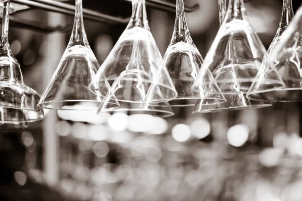 Empty glasses for wine above a bar rack — Stock Photo, Image