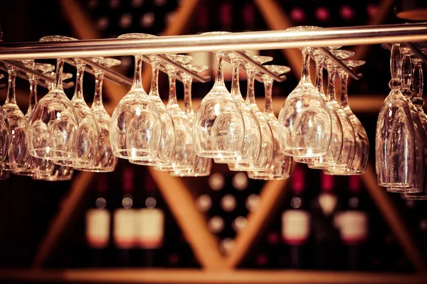 Empty glasses for wine above a bar rack — Stock Photo, Image