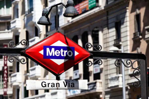 Metro tecken gran via på suddiga staden, madrid — Stockfoto