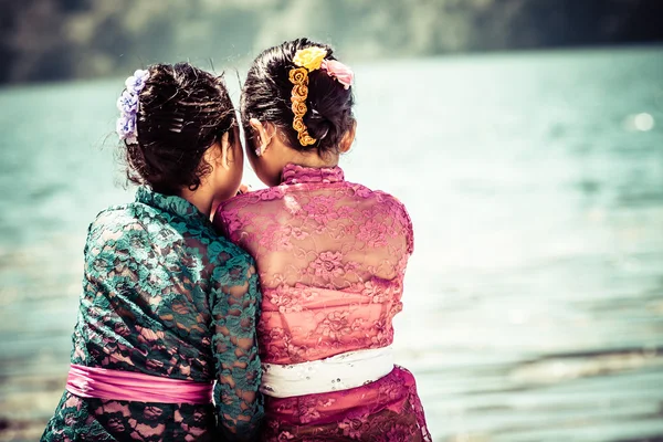 Twee jonge meisjes zitten dicht bij het meer. Bali. Indonesië — Stockfoto