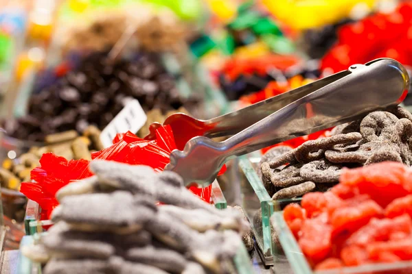 Barraca de mercado cheia de doces no Mercado La Boqueria. Barcelona. Catalunha . — Fotografia de Stock