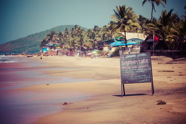 Anjuna Strandpanorama bei Ebbe mit weißem, feuchtem Sand und grünen Kokospalmen, Goa, Indien — Stockfoto