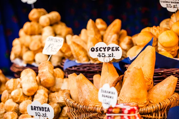 Hagyományos lengyel füstölt sajt oscypek szabadtéri piacon, Krakkó, Lengyelország. — Stock Fotó