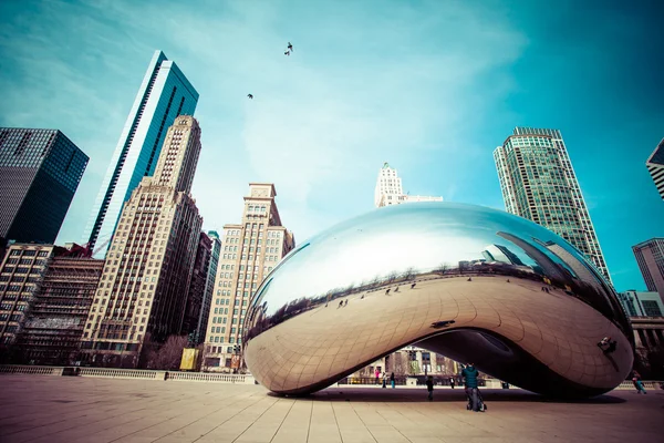 CHICAGO, IL - 2 APRILE: Cloud Gate e Chicago skyline il 2 aprile 2014 a Chicago, Illinois. Cloud Gate è l'opera d'arte di Anish Kapoor come il famoso punto di riferimento di Chicago nel Millennium Park . — Foto Stock