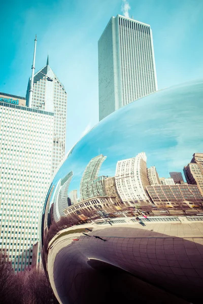 CHICAGO, IL - APRIL 2: Cloud Gate and Chicago skyline on April 2, 2014 in Chicago, Illinois. Cloud Gate is the artwork of Anish Kapoor as the famous landmark of Chicago in Millennium Park. — Stock Photo, Image