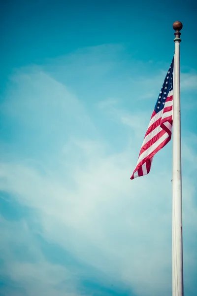 American flag - star and stripes floating over a cloudy blue sky — Stock Photo, Image