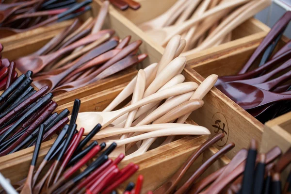 Cuchara de madera cucharaditas pequeñas nuevas no utilizadas de madera dura marrón para la venta en un mercado callejero en Tailandia — Foto de Stock