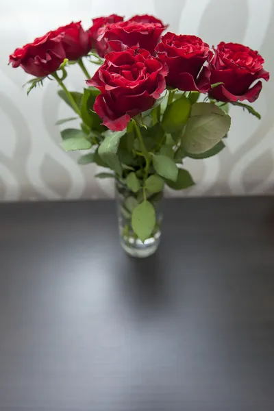 一朵朵深红色玫瑰插在花瓶里的花束 — 图库照片