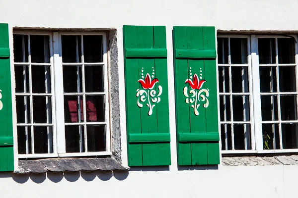 Typical germany windows with green shutters and window box — Stock Photo, Image