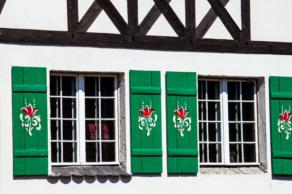 Typisch deutsche Fenster mit grünen Rollläden und Fensterkasten — Stockfoto