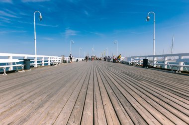 SOPOT, POLAND - 9 AUGUST: People on Sopot molo at Baltic Sea, 9 august 2014. Sopot is major health and tourist resort destination and this pier with 511.5 meters long is the longest wooden pier in Eur clipart