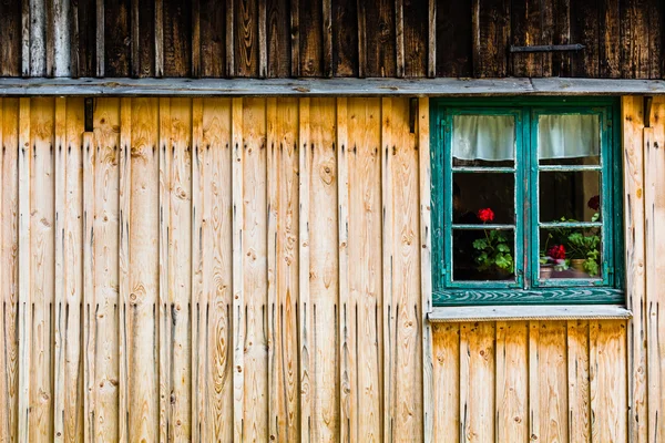 Zelené okno s červenými květy — Stock fotografie