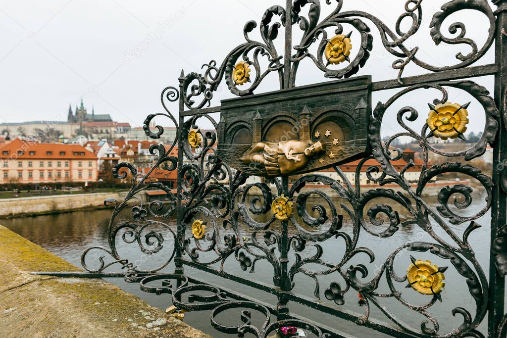 An old relief below the statue of St. John of Nepomuk on Charles Bridge in Prague, Czech Republic. According to legend good luck and a promise of return trip to Prague comes to those who touch it.
