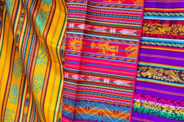 Otavalo, Ekvador 'daki yerel hediyelik eşya pazarında renkli And kumaşları. Güney Amerika.