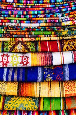 Otavalo, Ekvador 'daki yerel hediyelik eşya pazarında renkli And kumaşları. Güney Amerika.