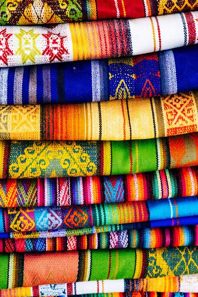 Otavalo, Ekvador 'daki yerel hediyelik eşya pazarında renkli And kumaşları. Güney Amerika.