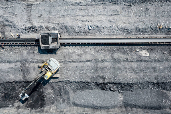 Aerial photo of excavator on industrial place. Construction site top view. Shooting from the drone.