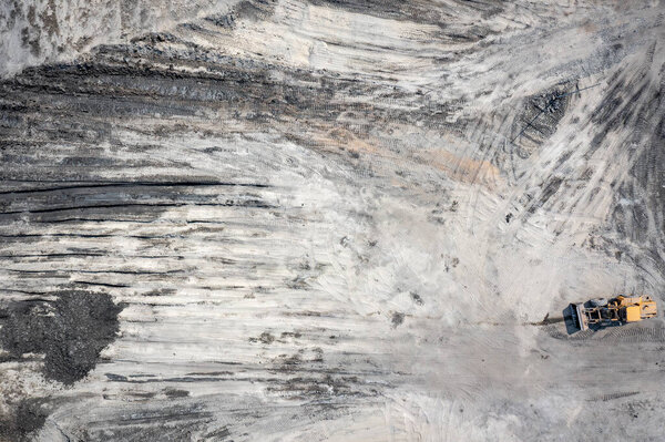 Аэрофотосъемка экскаватора на промышленном месте. Вид сверху на стройплощадку. Стрельба из беспилотника.