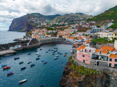 Madeira. Camara de Lobos Hava Manzarası. Körfezde bir sürü küçük teknesi olan küçük bir balıkçı köyü. Madeira Adası, Portekiz.