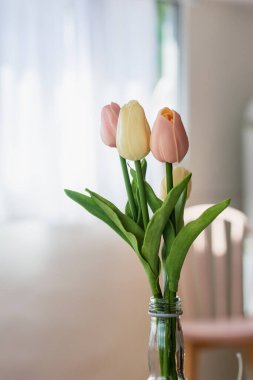 Güneşli bir günde laleler pencerenin önünde iç dekorasyon yapıyor. Romantik konsept.