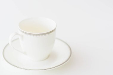 Doğal ışık arka planında beyaz porselen çay fincanı.