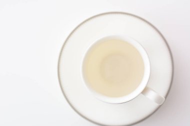 Doğal ışık arka planında beyaz porselen çay fincanı.