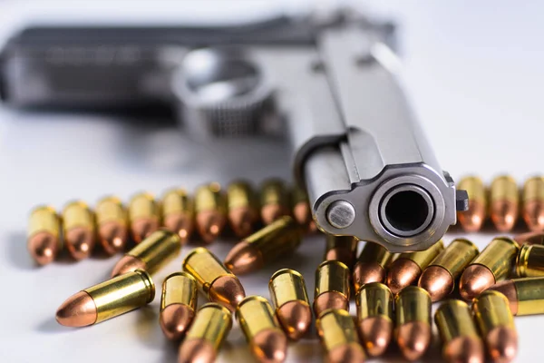 Doğal ışık arka planında bakır mermili yarı otomatik tabanca..