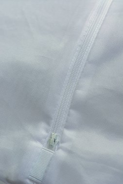 Beyaz naylon kumaşa bağlanmış plastik fermuar. Arkaplan için soyut.