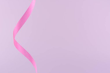 Curled ribbon on pink color background.