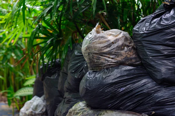 A pile of trash packed with biodegradable plastic bags on natural light background.