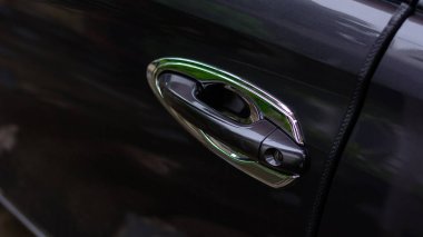 Black gray car door handle with chrome frame.