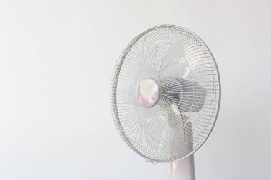 Dirty and dusty fan on white wall background.