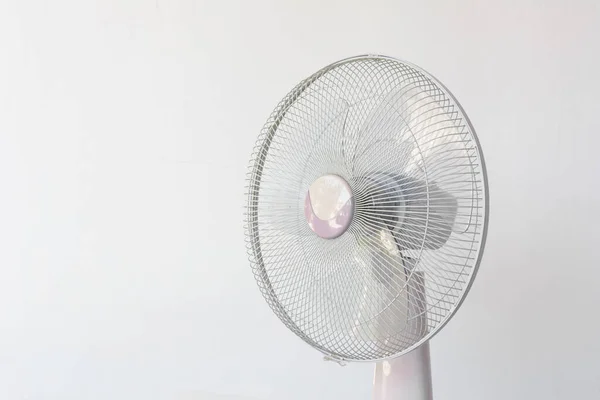 Dirty and dusty fan on white wall background.