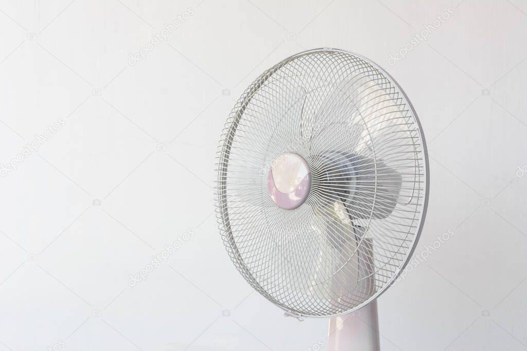 Dirty and dusty fan on white wall background.