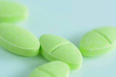 Cough pill on light green background. Health care concept.