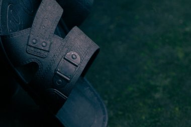 Black rubber sandal on natural low light background. Low key photography style.