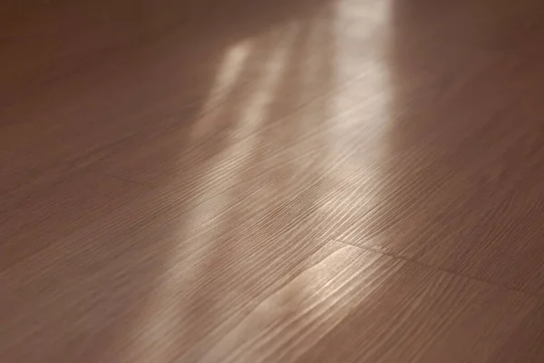 Brown laminate floor with natural light from window.