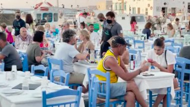 Paros, Cyclades Islands, Greece - 23 June: people sit smoke waiting for order traditional greek cafe restaurant tavern