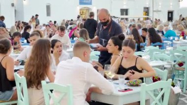 Paros, Cyclades Islands, Greece - 27 September: people order at a traditional Greek cafe outdoor tavern restaurant